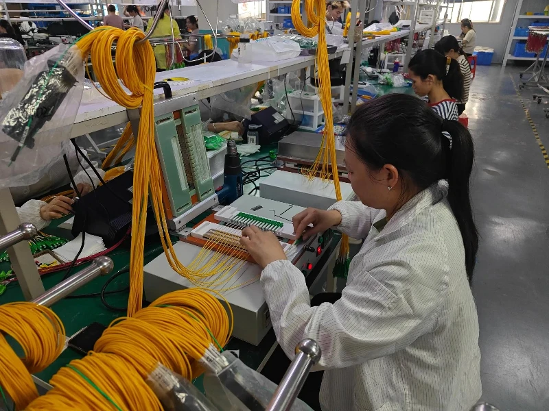 Technician assembling yellow single-mode fiber cable and connectors at a workbench Technician assembling yellow single-mode fiber cable and connectors at a workbench